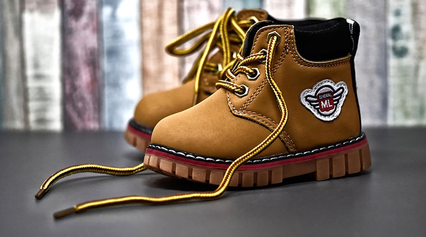 braune Kinderschuhe mit offenen Schnürsenkeln